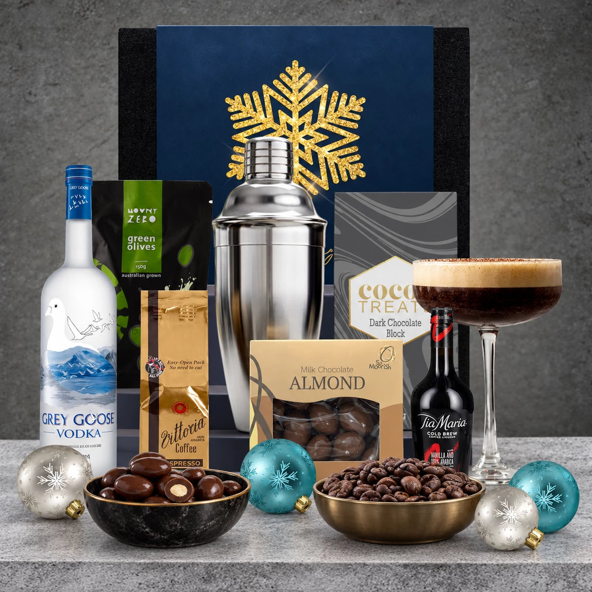 Christmas Cocktail Gift Pack featuring Grey Goose Original Vodka, Tia Maria liqueur, cocktail shaker and glass with gourmet treats.