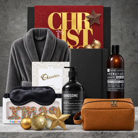 Men's Christmas self-care gift set with a luxury bath robe, pink grapefruit body wash, hand wash, brown toiletry bag and eye mask.