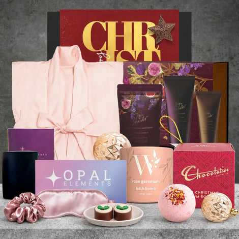 Rejuvenating Christmas self-care hamper featuring a satin bathrobe, fig and lavender body pamper set, bath bomb, silky eye mask, plum soy candle and Christmas chocolate