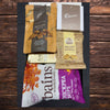 Christmas gift box filled with sweet and savoury snacks, including chocolates, cheese biscuits, caramel fudge and chickpea chips